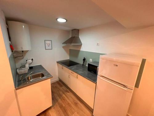 a kitchen with a white refrigerator and a sink at Apartamento en Santander in Santander