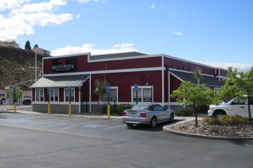 a red building with a car parked in a parking lot at America's Best Inn & Suites Saint George in St. George