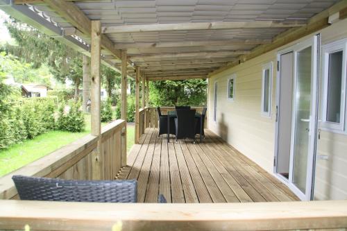 a deck with a pergola on a house at Chalet with large veranda 6p centrally located in National Park, Swimming pool 168 in Wateren