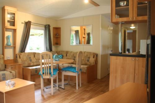 a kitchen and dining room with a table and chairs at Chalet with large veranda 6p centrally located in National Park, Swimming pool 168 in Wateren