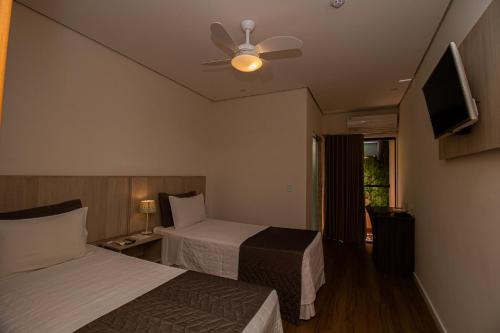 a hotel room with two beds and a ceiling fan at Prado Hotel in Amparo