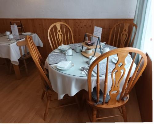 a table with chairs and a white tablecloth on it at Stepping Stones in Lincolnshire