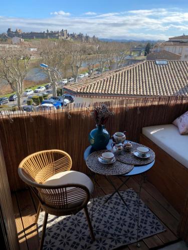stół i krzesła na balkonie z widokiem w obiekcie Magnifique appartement avec vue cité! w Carcassonne
