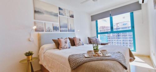 Un dormitorio con una cama con dos tazas. en Oasis en la cala a pasos de mar!! en Cala de Finestrat