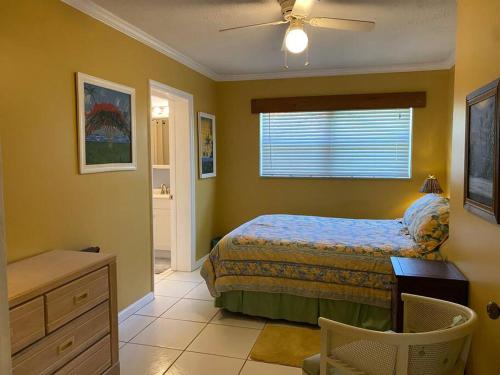 a bedroom with a bed and a desk and a window at Vintage Vero Bungalow in Vero Beach