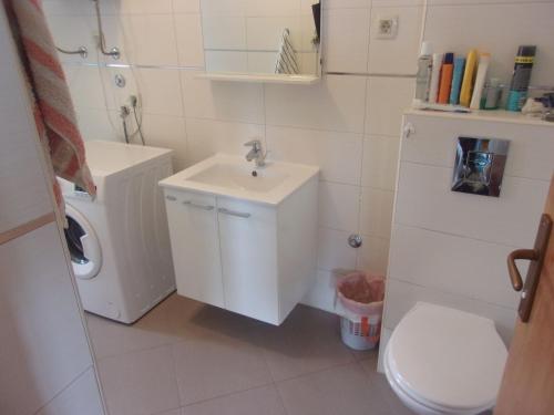 uma casa de banho branca com um lavatório e um WC em Rooms Port em Dubrovnik