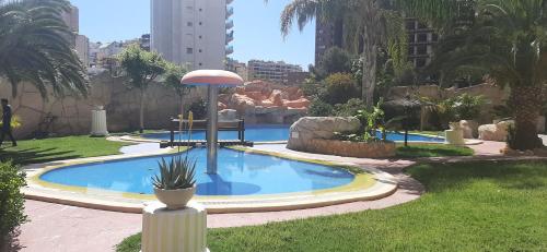 a swimming pool with a fountain in a city at Oasis en la cala a pasos de mar!! in Cala de Finestrat