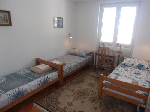 um quarto com 3 camas e uma cadeira e uma janela em Rooms Port em Dubrovnik