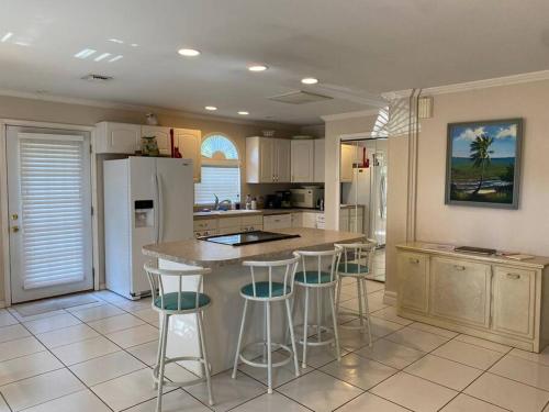 a kitchen with a island with bar stools at Vintage Vero Bungalow in Vero Beach
