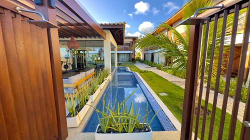- Vistas al exterior de una casa con piscina en Apto Novo beira-mar Praia de Itacimirim, en Itacimirim