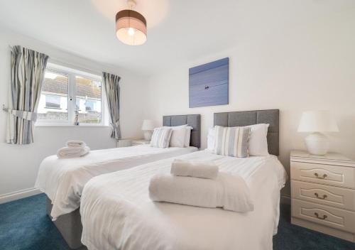 a bedroom with two beds with white sheets at Loveday in Porthleven
