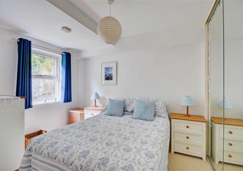 um quarto com uma cama com almofadas azuis em Blue Horizon em St Ives