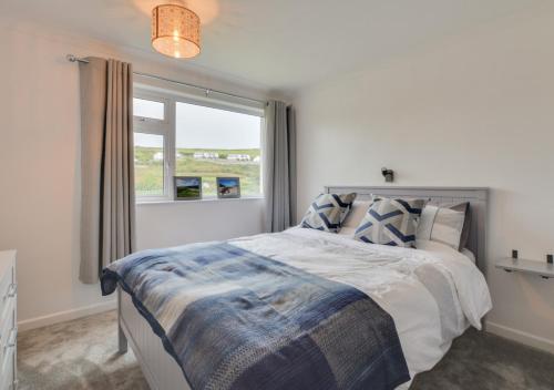 a bedroom with a large bed with a window at Pool and Valley View in Mawgan Porth