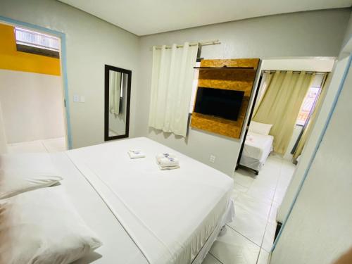 a bedroom with a large white bed and a mirror at Pousada Vila Mansa Jeri in Jericoacoara