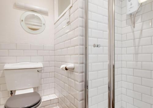 a white bathroom with a toilet and a shower at Riverside in Saint Breward