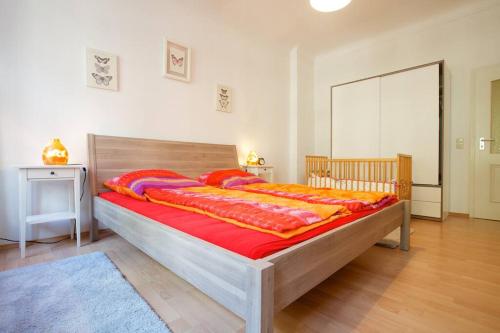 a bedroom with a large wooden bed with red sheets at Wohfühlen Garantiert Große Wohnung mit zwei Schlafzimmern und Terrasse in Görlitz