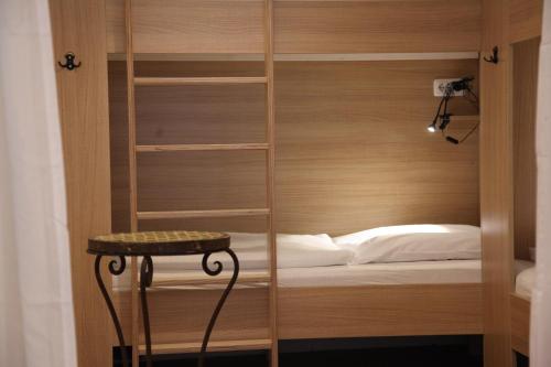 a room with a bunk bed with a table in it at Old Kings Design Hostel in Füssen