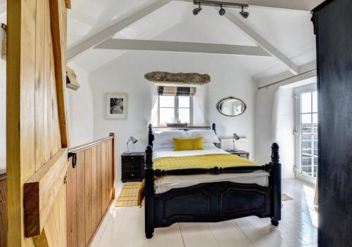 um quarto com uma cama com uma colcha amarela em The Byre - Sennen em Sennen