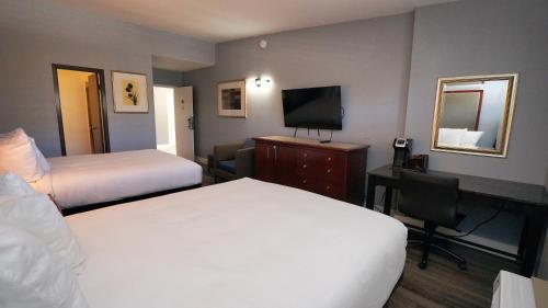 a hotel room with two beds and a television at SeaSide Inn & Suites in Santa Cruz