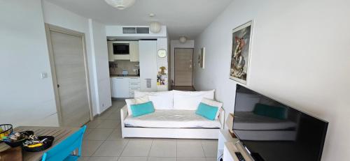 Cette petite chambre comprend un lit et une cuisine. dans l'établissement T2 de Standing Coté Plage, les pieds dans l'eau, à Propriano