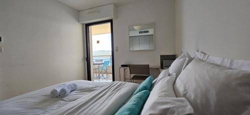a bedroom with a bed with a view of the ocean at T2 de Standing Coté Plage, les pieds dans l'eau in Propriano