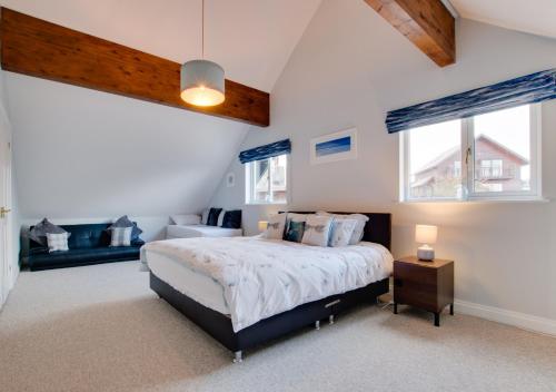 ein Schlafzimmer mit einem großen Bett und zwei Fenstern in der Unterkunft Sunrise in Saint Columb Major