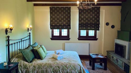 1 dormitorio con 1 cama y 2 ventanas en Giagia Evgenia, en Vitsa