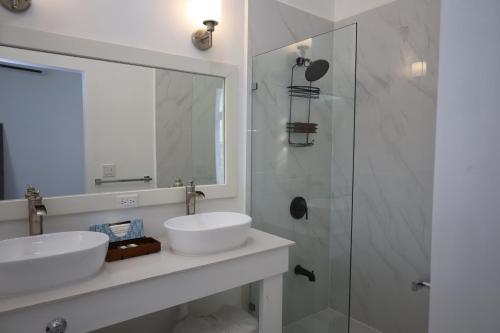 a bathroom with two sinks and a shower at The Ellysian Apartments in Placencia Village