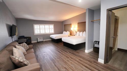 SeaSide Inn & Suites في سانتا كروز: غرفة فندقية بسريرين واريكة