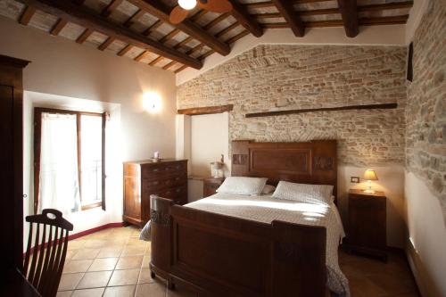 a bedroom with a bed and a stone wall at Relais B&B Corte Dei Turchi in Longiano