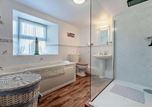 a bathroom with a tub and a toilet and a sink at Victoria House - St Issey in Saint Issey