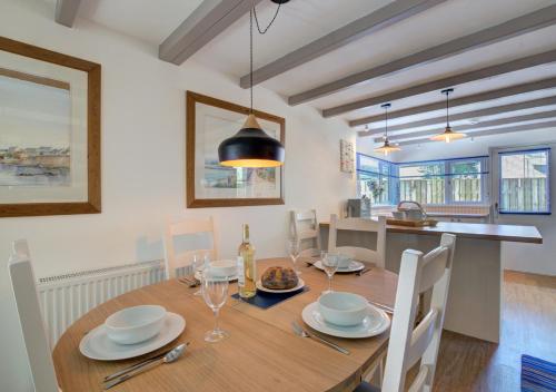 a dining room with a wooden table with chairs at Tremenhere Barn in Saint Keverne