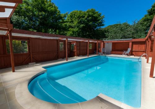 a swimming pool on a patio with a house at Tremenhere Barn in Saint Keverne