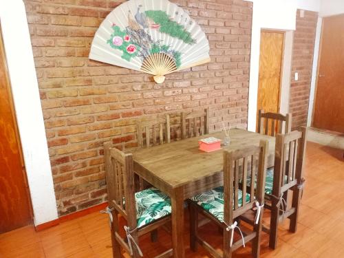 a dining room table with chairs and a brick wall at Complejo Hatun Yaya in Mendoza