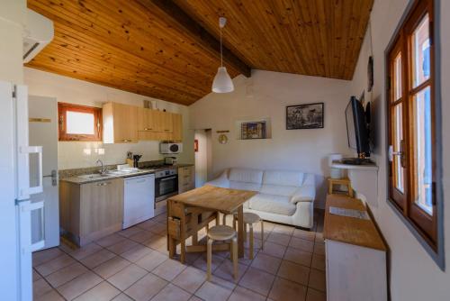 a kitchen and living room with a table and a couch at Résidence Itylon in Cargèse