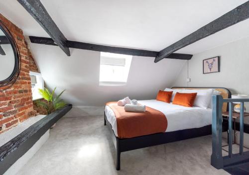 um quarto com uma cama e uma parede de tijolos em Pike Cottage em Kettleburgh