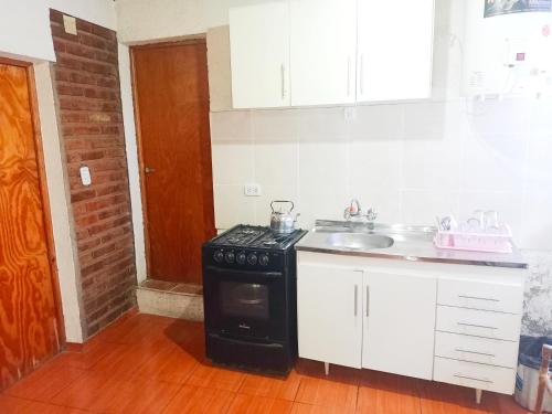a kitchen with a stove and a sink at Complejo Hatun Yaya in Mendoza