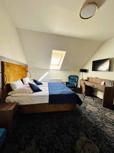a bedroom with a large bed and a desk at Hotel Wellness & Spa Nowy Dwór in Rzeszów