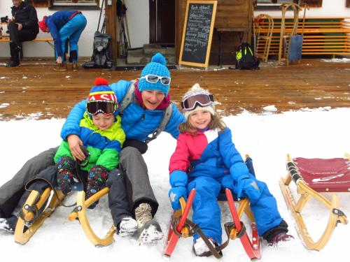 a man and two children sitting in the snow on skis at Apartement Gute Laune in Mieming
