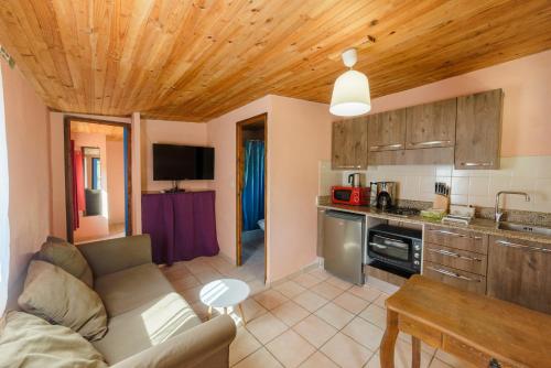a living room with a couch and a kitchen at Résidence Itylon in Cargèse