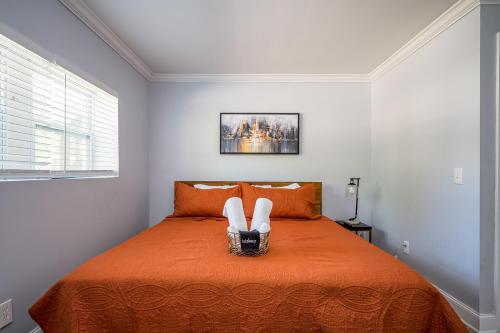 a bedroom with a large orange bed with two white chairs at NEW Spacious Decatur Oasis w Fire Pit, Mins to ATL in Decatur