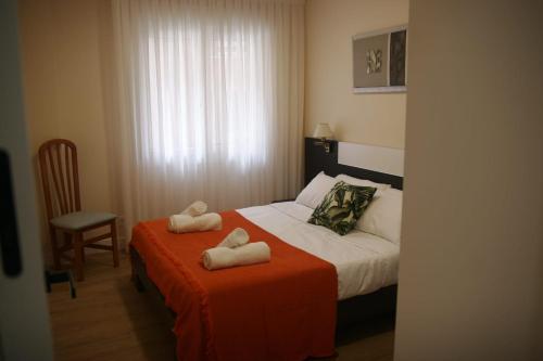 a bedroom with a bed with two towels on it at Astillerogane in Bermeo