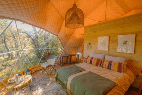 sypialnia z łóżkiem i dużym oknem w obiekcie Chalten Camp - Glamping with a view w mieście El Chaltén