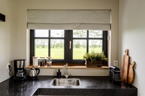 a kitchen with a sink and a window at Het Landzicht 