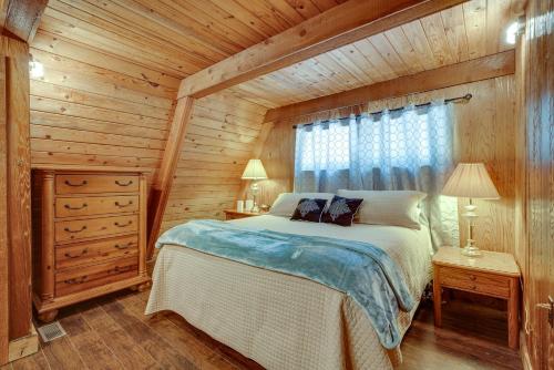 ein Schlafzimmer mit einem Bett in einer Holzhütte in der Unterkunft Lakefront A-Frame Cabin with Community Perks in Columbia