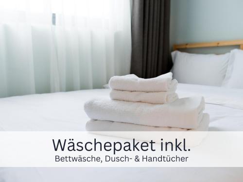a pile of towels sitting on top of a bed at Bergliebe - Talstation in Blaichach