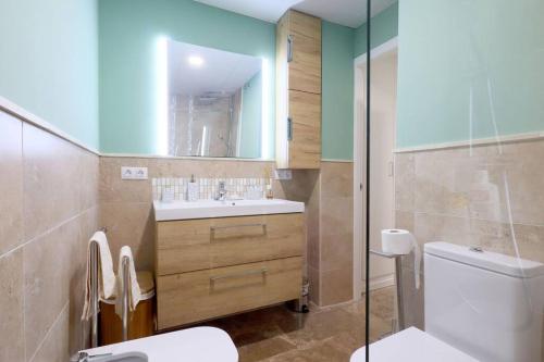 y baño con lavabo, aseo y espejo. en casa de los patios amurallados, en Córdoba