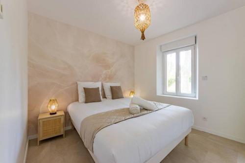 une chambre blanche avec un grand lit et une fenêtre dans l'établissement Le Rivera - Clim - Parking - Netflix - Nestor & Margot, à Auterive