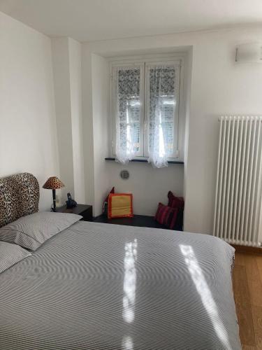 a bedroom with a large bed and two windows at Casa ORRI quinto mare e Gaslini in Genova