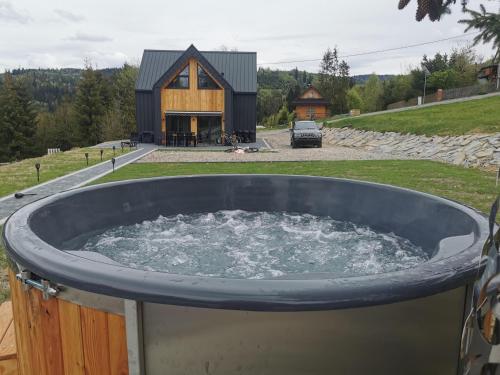 a large tub of water in front of a house at Beskidzka Stodoła przy szlaku z pięknym widokiem in Złatna
